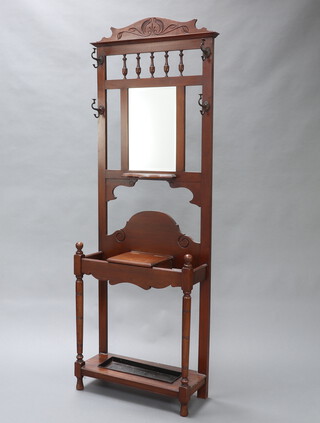 Co-Op Wholesale Society, an Edwardian walnut hall stand with carved and shaped back and bobbin turned decoration, fitted a rectangular plate mirror flanked by 4 coat hooks, the base with umbrella stand raised on turned supports complete with drip tray 84cm h x 69cm w x 29cm d, t he reverse with label Manufactured by The Co-Op Wholesale Society Cabinet Makers Broughton Manchester 