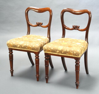A pair of Victorian mahogany spoon back dining chairs with carved mid rails and over stuffed seats raised on turned supports 86cm h x 48cm w x 41cm d (seat 30cm x 27cm) 