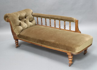 An Edwardian walnut framed chaise longue upholstered in buttoned material with bobbin turned decoration, raised on turned supports 70cm h x 170cm w x 57cm w (seat 125cm x 38cm) 