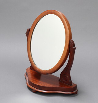 A Victorian oval dressing table mirror contained in a mahogany swing frame with shaped base 59cm h x 49cm w x 23cm d 