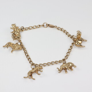 A yellow metal charm bracelet with 5 charms, 23 grams 