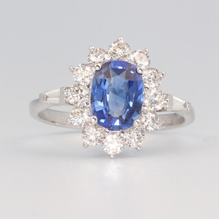 A white metal stamped 750 oval sapphire and diamond cluster ring, the centre stone 1.64ct, the brilliant cut diamonds 0.9ct, size N 1/2, 3.6 grams 