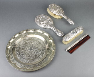 A Victorian style repousse silver 4 piece dressing table set decorated with masks and scrolls, comprising hairbrush, clothes brush, hand mirror and comb, London 1968, together with a metal tray  