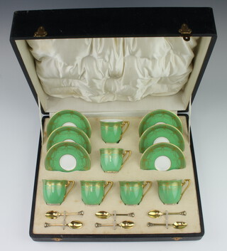 A set of 6 Royal Worcester coffee cups and saucers with pale green and gilt decoration, together with 6 silver gilt coffee spoons London 1929, cased 