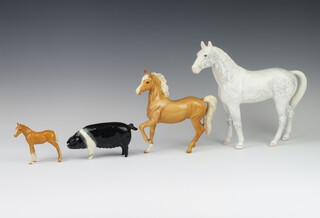 A Beswick figure of a Palomino prancing Arab by Arthur Greddington H1261, first version 17cm, ditto Palomino pony 9cm together with a Beswick pig (stuck leg), walking rocking horse grey horse 23cm 
