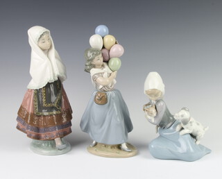 A Lladro figure of a seated girl with kitten and puppy 17cm, a ditto of a Spanish girl 27cm and a girl holding balloons 27cm 