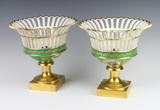 A pair of Sevres style pierced centrepieces, the green and gilt ground decorated with spring flowers, raised on square bases 23cm  