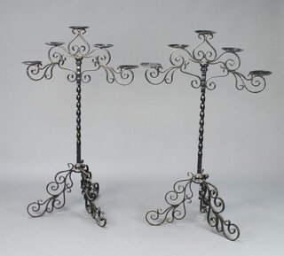 A pair of wrought iron 5 light candelabrum raised on shaped feet 116cm h x 73cm w the base 60cm d 