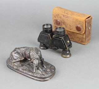 A bronzed figure of a reclining hound 5cm x 15cm x 7cm together with a pair of Negretti & Zambra folding 8X field glasses marked 16678 J.D.Moeller Wedel contained in a leather case 
