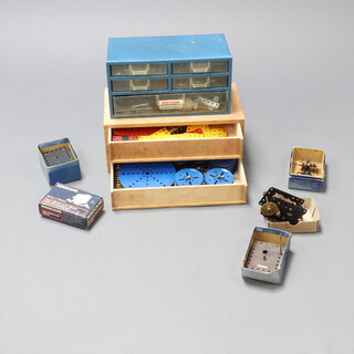 A plywood chest of 2 drawers containing pieces of yellow and blue Meccano, Meccano clockwork motor etc 