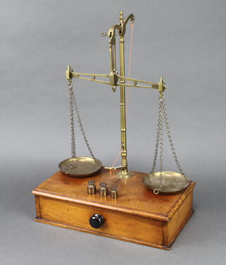 W & T Avery Ltd, a set of brass scales raised on a mahogany base with drawer, together with 3 brass bells weights - 2 x 2oz and 1oz 48cm h x 36cm w x 20cm d 