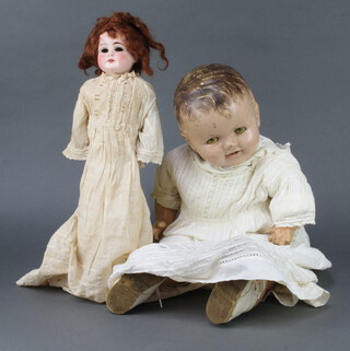 An unmarked 19th Century porcelain headed doll with open mouth and teeth, having leather body 45cm overall, together with a plastic headed doll with fabric body and plastic limbs 59cm 