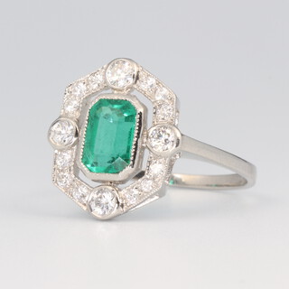 A white metal stamped plat. emerald and diamond cluster ring, the emerald cut stone approx. 0.9ct surrounded by brilliant cut diamonds 0.5ct, size N, 3.6 grams 