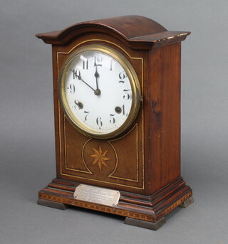 Waterbury Clock Co., a striking bracket clock with enamelled dial and Arabic numerals, contained in an arch shaped inlaid mahogany case with silver presentation plaque "Presented to Police Constable Thomas Smith by the Officers, Sergeants and Constables of the Church Division .... 1916", complete with pendulum and key  33cm x 23cm x 24cm