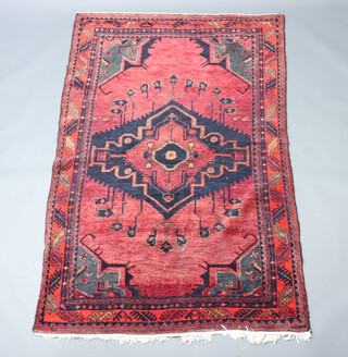 A red and blue ground Afghan rug with diamond shaped medallion to the centre 230cm x 150cm 
