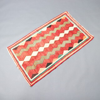 A red, green and white ground tribal rug with overall geometric design 147cm x 87cm 