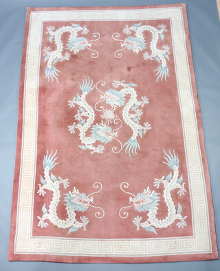 A peach ground Chinese carpet with dragon decoration and Grecian key border 277cm x 185cm 