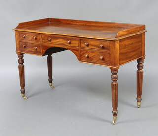 A Gillows style mahogany dressing table with three quarter gallery, fitted 1 long and 4 short drawers, raised on turned and reeded supports, brass caps and casters 79cm h x 121cm w x 52cm d  