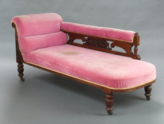 A late Victorian carved mahogany show frame chaise longue upholstered in pink material, raised on turned supports 77cm h x 167cm l x 61cm w 