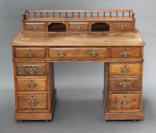 A Victorian light oak Dickens style desk having a raised superstructure to the back with 3/4 gallery, fitted 3 drawers flanked by a pair of apertures, the base fitted 1 long and 6 short drawers 97cm h x 122cm w x 71cm d  