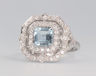 A white metal stamped 18k aquamarine and diamond ring, the centre square cut stone approx. 1.0ct, surrounded by brilliant cut diamonds, 4.2 grams, size N 