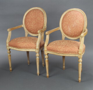 A pair of Empire style, carved beech, open arm salon chairs, raised on turned and reeded supports 97cm h x 56cm w x 47cm d (seat 32cm x 30cm) 
