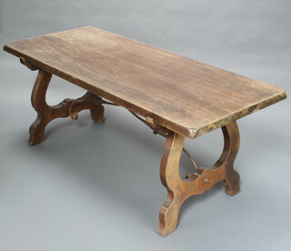 A Spanish style beech refectory dining table, raised on shaped supports with iron stretcher 74cm h x 179cm w x 79cm d 