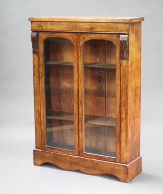 A Victorian inlaid walnut display cabinet fitted shelves enclosed by arched glazed panelled doors, raised on a shaped base 102cm h x 79cm w x 26cm d 