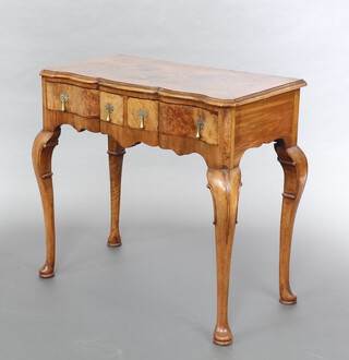 A Queen Anne style bleached walnut side table of serpentine outline with quarter veneered top fitted 2 long drawers, raised on cabriole supports 73cm h x 76cm w x 42cm d 