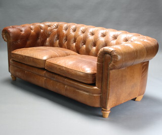 A two seat Chesterfield upholstered in brown buttoned leather 73cm h x 197cm w x 90cm d (seat 166cm x 60cm) 