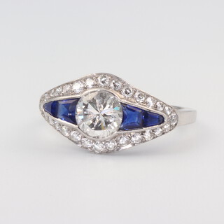 A BOODLES diamond and sapphire ring, the centre brilliant cut diamond (with a LCCI report, rare white, VVS2, 1.01ct approximately 6.32mm x 4.01mm GB 2389 dated 1984) flanked by 2 tapered sapphires and surrounded by brilliant cut diamonds 0.30ct, size O, 5.5 grams