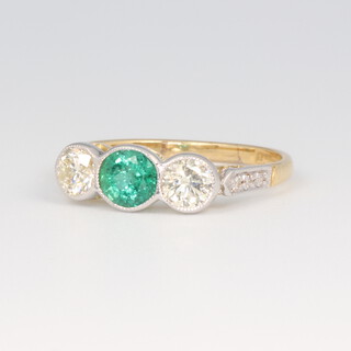A yellow metal stamped 18ct emerald and diamond ring, the oval centre stone 0.7ct, the 2 brilliant cut diamonds 0.5ct, size N 1/2, 2.5 grams 