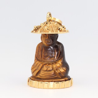 A yellow metal 18k mounted carved tigers eye figure of a seated chinaman 30mm, 10 grams gross 