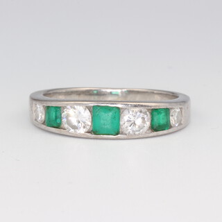 A white metal stamped 750 emerald and diamond ring, the 3 princess cut emeralds 0.4ct, the 3 brilliant cut diamonds 0.7ct, size O, 5.2 grams