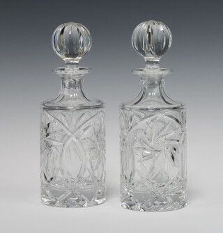 A pair of circular cut glass spirit decanters and stoppers 24cm 