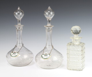 A pair of Edwardian decanters and stoppers with engraved fern decoration 32cm, with enamelled Sherry and Scotch labels, together with a square spirit decanter and stopper 22cm 