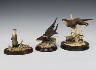 A Border Fine Arts figure of an otter by E Waugh, dated 1989 on a wooden socle base 19cm, ditto of 2 otters by Ayres no.1071 of 3000 on a wooden socle base 17cm and 1 other of an otter standing on its hind legs by Ayres 14cm on a wooden socle base 