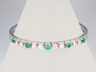 A white metal stamped 750 diamond and emerald bracelet comprising 8 brilliant cut diamonds approx. 0.15ct each and 4 brilliant cut emeralds approx. 0.25ct each, 24.4 grams, 18.5cm in length 