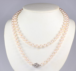 A strand of 106 cultured pearls each approx. 6mm with a white metal stamped 585 diamond set ball clasp 95cm 