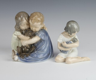 A Royal Copenhagen group of 2 children cuddling a dog 707 16cm together with a ditto of a seated girl holding a doll 1938, 13cm 