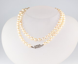 A strand of 84 cultured pearls, each approx. 5mm, with a white metal set 8 stone diamond clasp, 65cm 