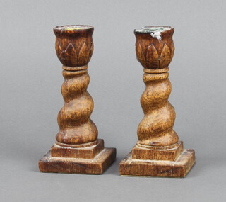 A pair of 1930's oak spiral turned candlesticks, raised on square bases 16cm h x 7cm 