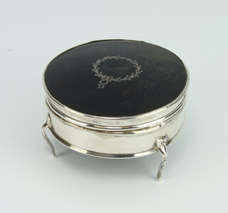 An Edwardian silver and tortoiseshell circular trinket box raised on scroll legs, rubbed marks 7cm 