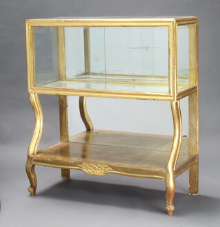 A 19th Century rectangular gilt painted display cabinet with mirrored back and base with undertier, raised on scroll supports 101cm h x 89cm w x 36cm d 