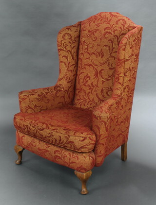 A Georgian style winged armchair upholstered in gold and floral patterned material, raised on cabriole supports 120cm h x 87cm w x 69cm d (seat 40cm x 40cm) 