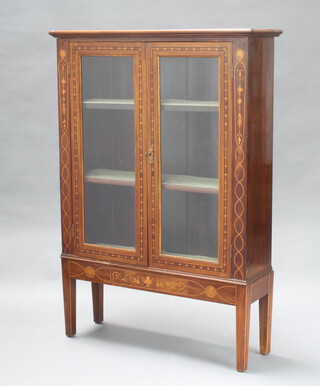 An Edwardian Dutch style inlaid mahogany display cabinet fitted shelves enclosed by glazed panelled doors, raised on square supports 129cm h x 89cm w x 29cm d 