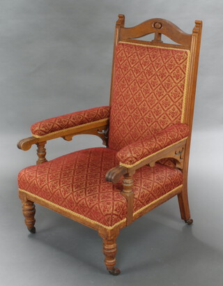 An Edwardian Art Nouveau oak show frame open arm chair, upholstered in red and gold material 114cm h x 69cm w x 66cm d (seat 36cm x 39cm)