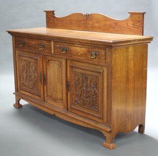 An Edwardian Art Nouveau carved oak sideboard with associated raised shaped back above 2 drawers, base fitted triple cupboards enclosed by carved and panelled doors, raised on square supports 120cm h x 181cm w x 57cm d 