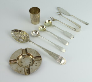 A Georgian silver berry spoon rubbed marks, an ashtray, tot, 3 mustard spoons, nips and a butter knife, 128 grams 
