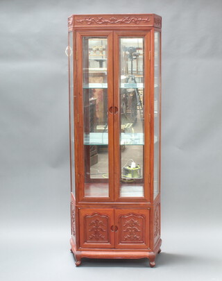 A 20th Century Chinese hardwood display cabinet with mirrored back fitted and adjustable shelves enclosed by glazed panelled doors, base enclosed by panelled doors 198cm h x 76cm w x 36cm 